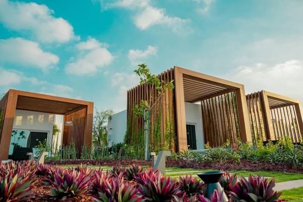 Außenbereich des Rixos Gulf Hotel Doha mit Holzstrukturen und Pflanzen