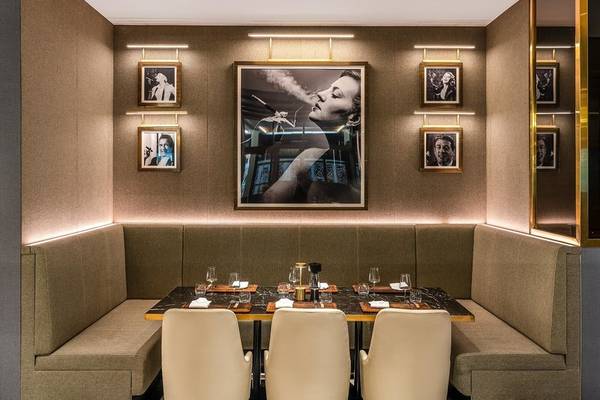 Innenraum des Rixos Gulf Hotel Doha mit einem großen Bild und vier kleineren Porträts an der Wand.