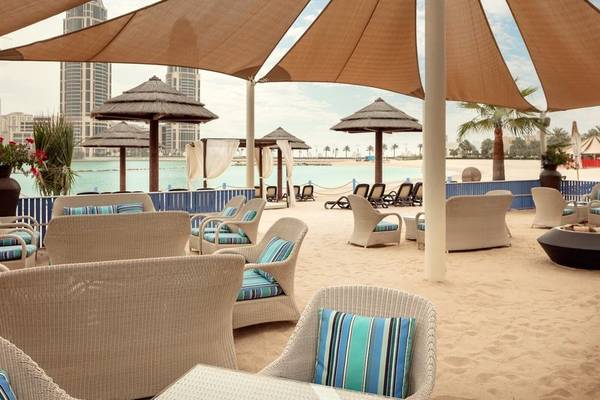 Terrasse des Grand Hyatt Doha Hotel & Villas mit Strandblick und Sonnenschirmen