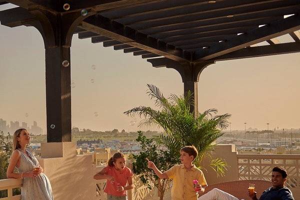 Familie auf der Terrasse des Grand Hyatt Doha Hotel & Villas, mit Blick auf die Stadt