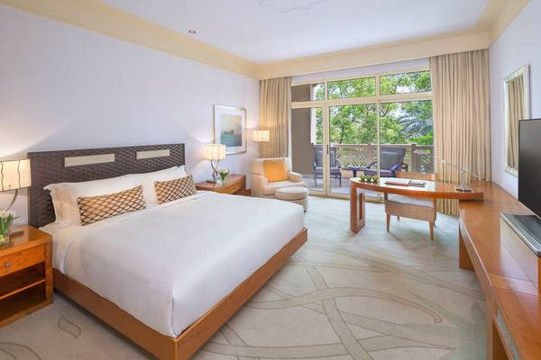 Schlafzimmer des Grand Hyatt Doha Hotel & Villas mit großem Bett, Fenstern mit Blick auf die Terrasse und natürliches Licht.