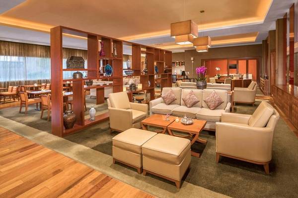 Lounge-Bereich im Grand Hyatt Doha Hotel & Villas mit modernen Möbeln, Holzböden und dekorativen Elementen.