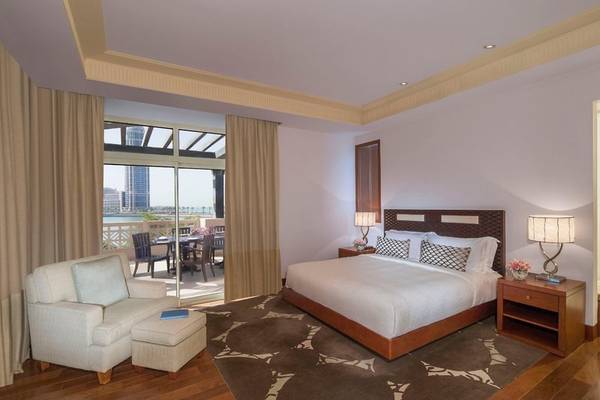 Schlafzimmer im Grand Hyatt Doha Hotel & Villas mit Bett, Sessel, Tisch und Meerblick