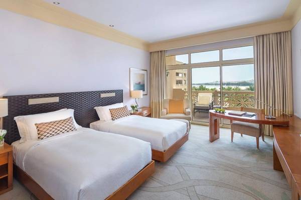 Zimmer im Grand Hyatt Doha Hotel & Villas mit zwei Betten und Blick auf das Meer.
