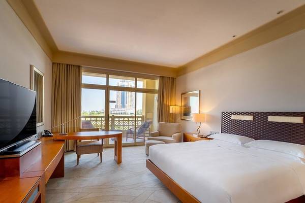 Suite-Zimmer im Grand Hyatt Doha Hotel & Villas mit großem Bett, Fernseher, Schreibtisch und Balkon
