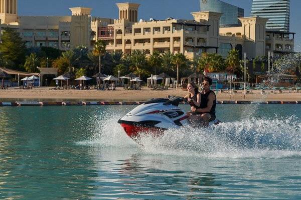 Zwei Leute auf einem Jetski vor dem Grand Hyatt Doha Hotel & Villas