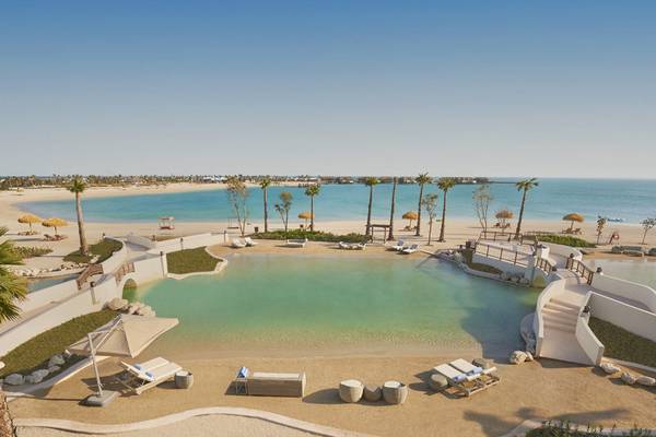 Luftaufnahme des Banana Island Resorts Doha von Anantara mit Strand, Pool und Palmen