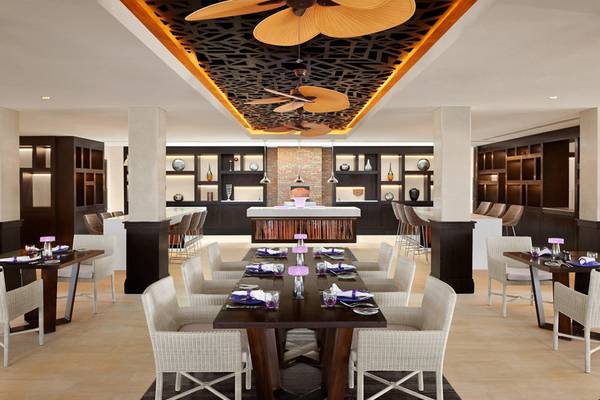 Innenansicht des Restaurants im Banana Island Resort Doha von Anantara mit langen Tisch, Stühlen und moderner Einrichtung.
