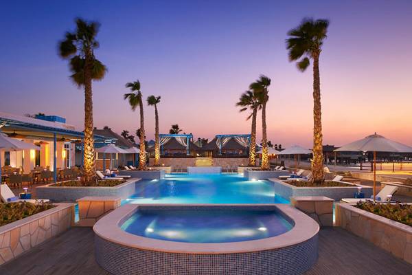 Außenpool des Banana Island Resorts Doha von Anantara bei Nacht
