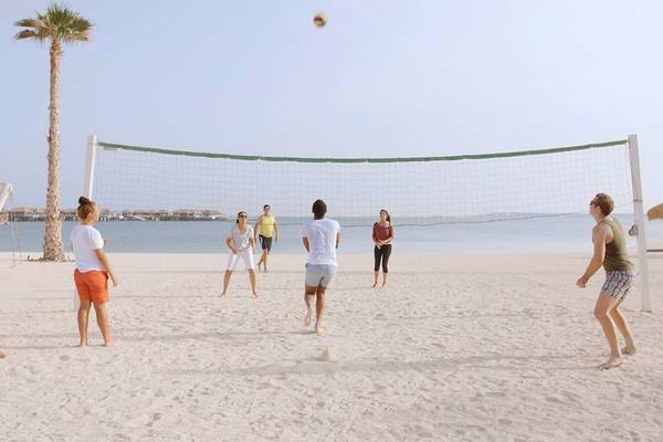 Gruppe spielt Volleyball am Strand des Banana Island Resorts in Doha.