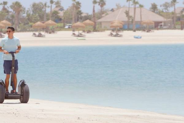 Fahrer auf einem Segway an der Strandlinie des Banana Island Resorts Doha von Anantara.