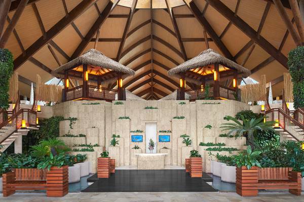 Eingangsbereich des Banana Island Resorts Doha mit Pflanzen und zwei runden Pavillons