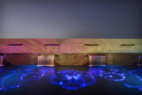Beleuchteter Pool mit farbigen Wasserstrahlen im W Doha Hotel.