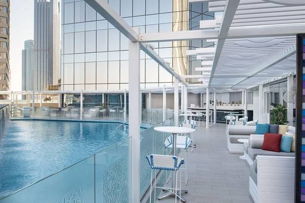 Außenpoolbereich des W Doha Hotel & Residences mit modernem Design und weißen Möbeln.