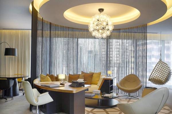 Inneneinrichtung des W Doha Hotel mit Bürotisch, Sofa, Schreibtischlampen und Kronleuchter.