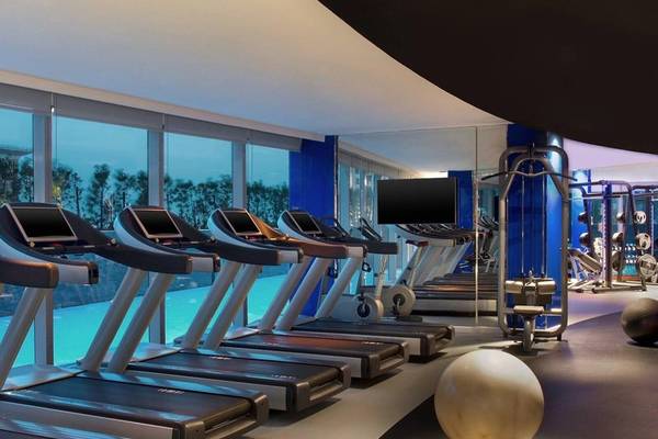 Fitnessstudio im W Doha Hotel & Residences mit mehreren Laufbändern und Trainingsgeräten.