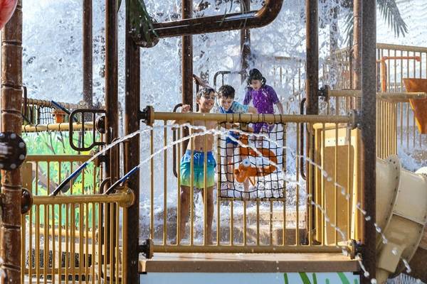 Kinder im Wasserspiel im Walddorf des Waldorf Astoria Doha Lusail