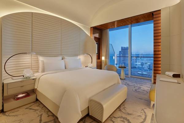 Schlafzimmer im Fairmont Doha mit großem Bett, Nachttischen und Stadtblick