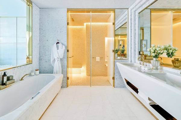 Elegantes Badezimmer im Fairmont Doha Hotel mit Marmorboden, Badewanne und Waschbecken.