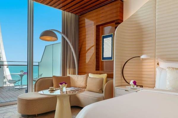 Innenansicht der Suite im Fairmont Doha mit Blick auf das Meer, modernes Dekor und Möbeln.