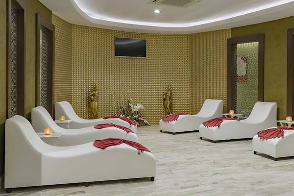 Spa-Bereich im Royal Taj Mahal Hotel mit weißen Liegen und goldenen Wänden.
