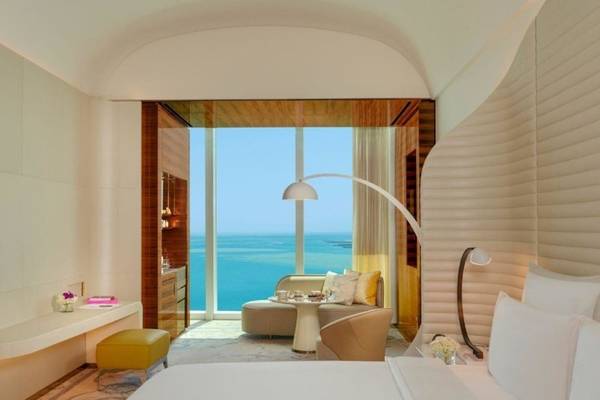 Fairmont Doha Hotelzimmer mit Meerblick, Bett, Sofa, Tisch und Fenster.