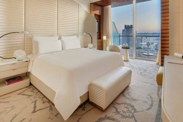Schlafzimmer im Fairmont Doha mit großem Bett, Aussicht auf die Stadt und Meer.