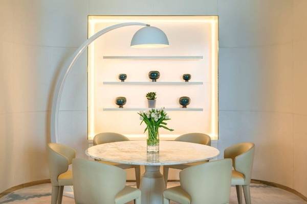 Elegantes Speisezimmer im Fairmont Doha mit einem runden Marmortisch und weißen Stühlen.