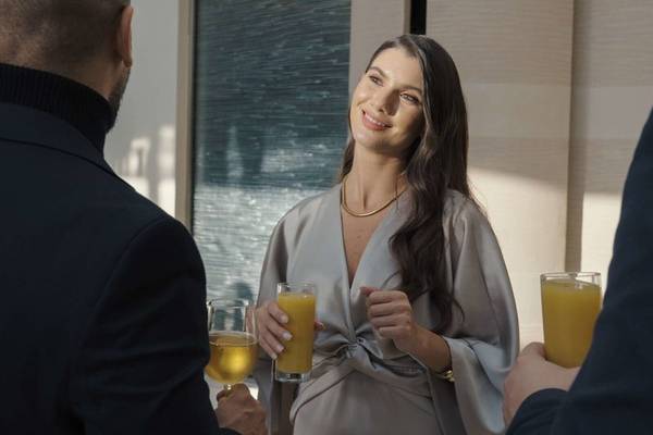 Frau im grauen Kleid trinkt Cocktail im Hyatt Regency Oryx Doha