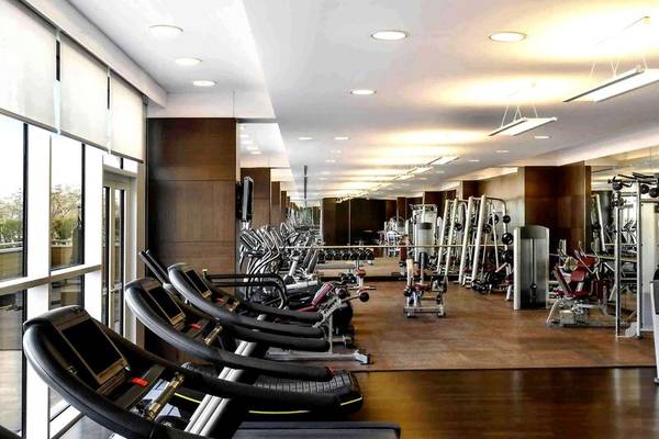Fitnesscenter im Hyatt Regency Oryx Doha mit vielen Geräten und Geräten, die in einer Reihe aufgestellt sind.