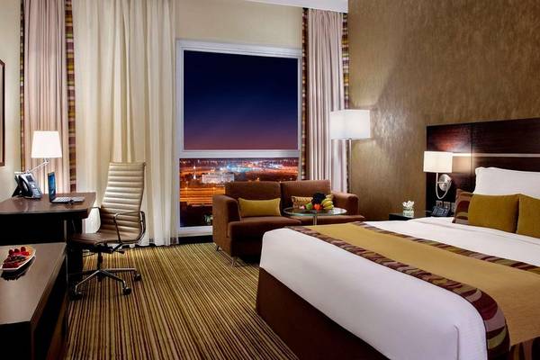 Hyatt Regency Oryx Doha Hotelzimmer mit Bett, Schreibtisch und Aussicht auf die Stadt.