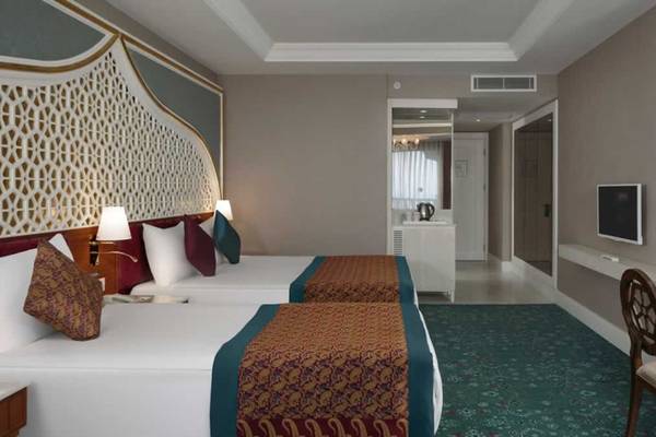 Doppelzimmer im Royal Taj Mahal Hotel mit zwei Betten, Dekor und Möbeln.