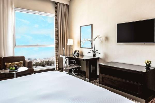 Zimmer im Hyatt Regency Oryx Doha mit Schreibtisch, Fernseher und Fensterblick.