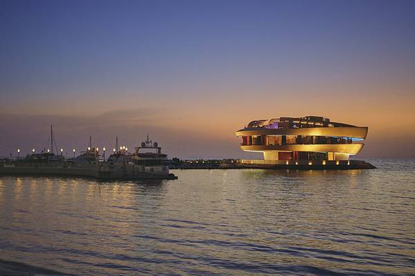 Vier Seasons Hotel Doha bei Sonnenuntergang mit Gebäude auf der Wasserfront beleuchtet