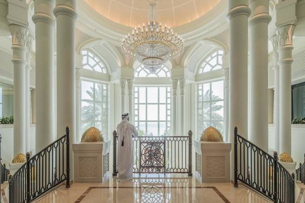 Ein Mann im weißen Gewand steht in der Foyer des Four Seasons Hotel Doha.
