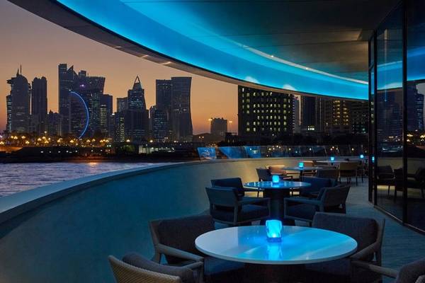 Außenterrasse des Four Seasons Hotel Doha bei Nacht mit Blick auf die Skyline