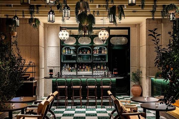 Innenansicht der Cocktailbar im Four Seasons Hotel Doha mit grünem Boden und hängenden Pflanzen.