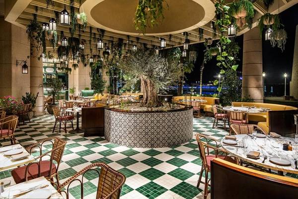 Innenbereich des Restaurants im Four Seasons Hotel Doha mit grünen Fliesenboden und grünen Pflanzen.