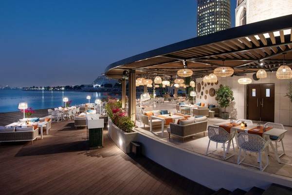 Außenterrasse des Four Seasons Hotel Doha mit Blick auf den See und die Stadt bei Nacht