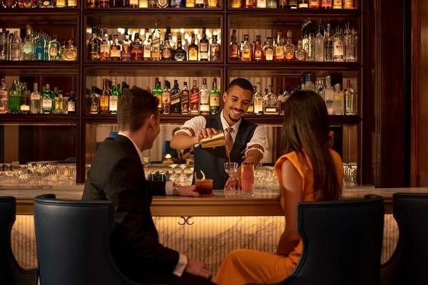 Ein Barkeeper serviert Getränke im Four Seasons Hotel Doha an einer Bar.