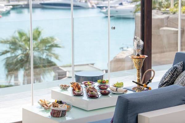 Aussicht auf den Hafen vom Four Seasons Hotel Doha mit gekochten Gerichten auf dem Tisch