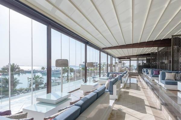 Loungebereich des Four Seasons Hotel Doha mit Blick auf den Hafen und moderne Möbel.