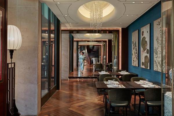 Restaurantbereich im Mandarin Oriental Doha mit Holzboden und blauen Wänden.