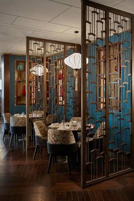 Innenansicht des Restaurants im Mandarin Oriental Doha mit geometrischen Trennwänden und blauen Wänden.