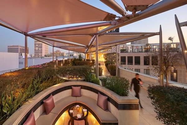 Aussicht von der Terrasse des Mandarin Oriental Doha Hotels mit einem Spaziergänger und Pflanzen.