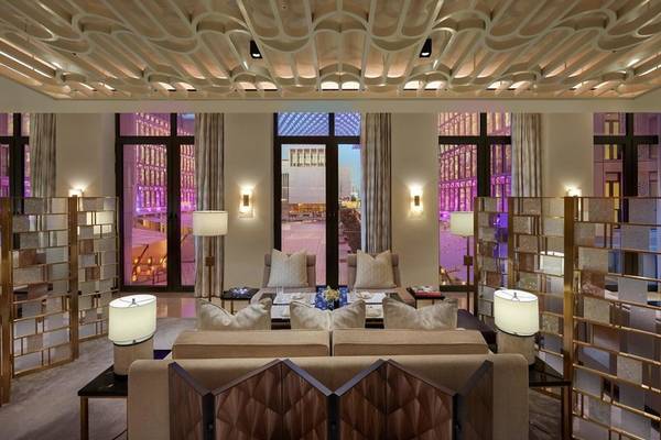 Innenraum des Mandarin Oriental Doha mit großen Fenstern, Möbeln und Lampen.