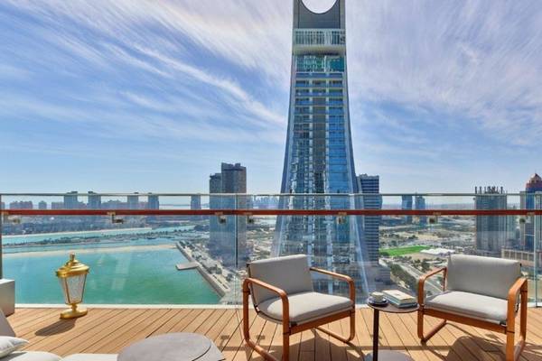 Ausblick vom Raffles Doha Hotel auf eine Skyline mit hohen Gebäuden und einem Meer.