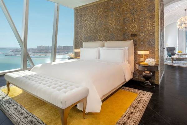 Luxuriöse Suite im Raffles Doha mit Bett, Meerblick und Dekor.