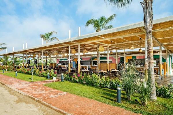 Außenbereich des Grand Park Lara Restaurants mit Tischen und Stühlen unter einem Dach.