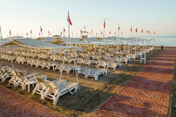 Strandbereich des Grand Park Lara Hotels mit vielen Sonnenliegen und Sonnenschirmen